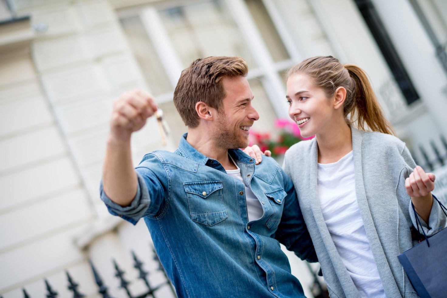Una pareja sonríe con las llaves de su nueva casa